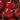 A close-up of ripe Bing cherries. They are a bright, darker red with green stems.